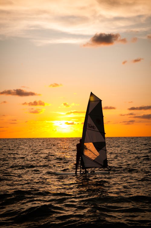 Silhouette of a Person Windsurfing during Sunset