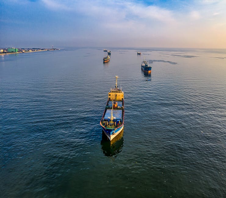 An aerial view of multiple cargo ships navigating the waters near Jakarta, Indonesia.