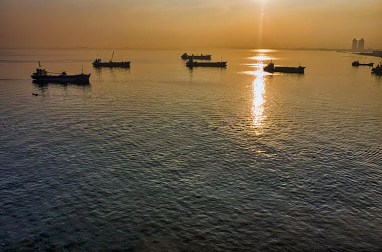 Silhouette Of Ships On Sea During Sunset