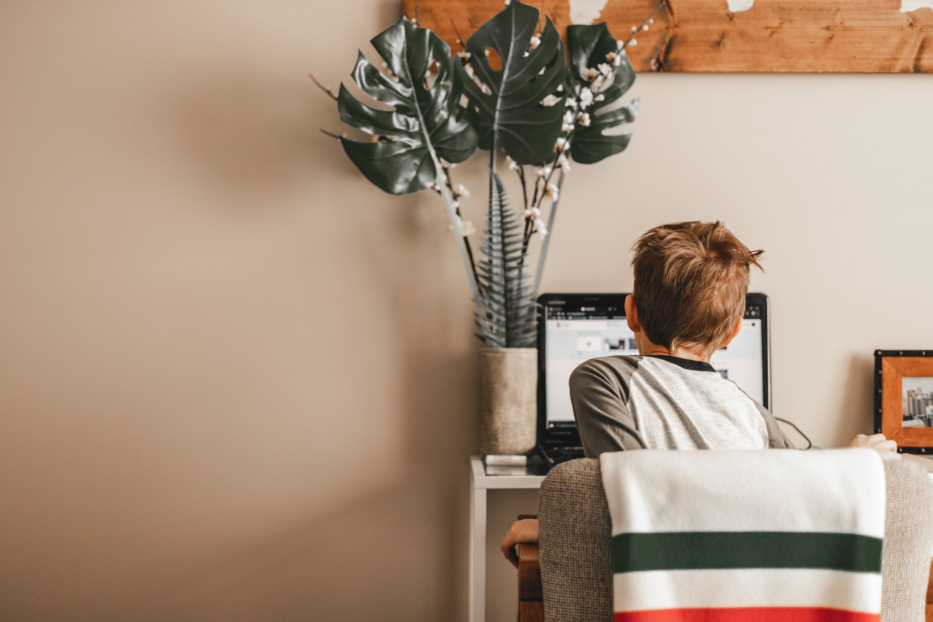 A student learning online on a laptop at home.