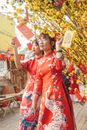 两名身穿红色奥黛的妇女用黄色的花朵和装饰品庆祝充满活力的春节