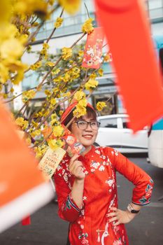 一位身着传统服装的亚洲妇女面带微笑，用节日装饰庆祝农历新年