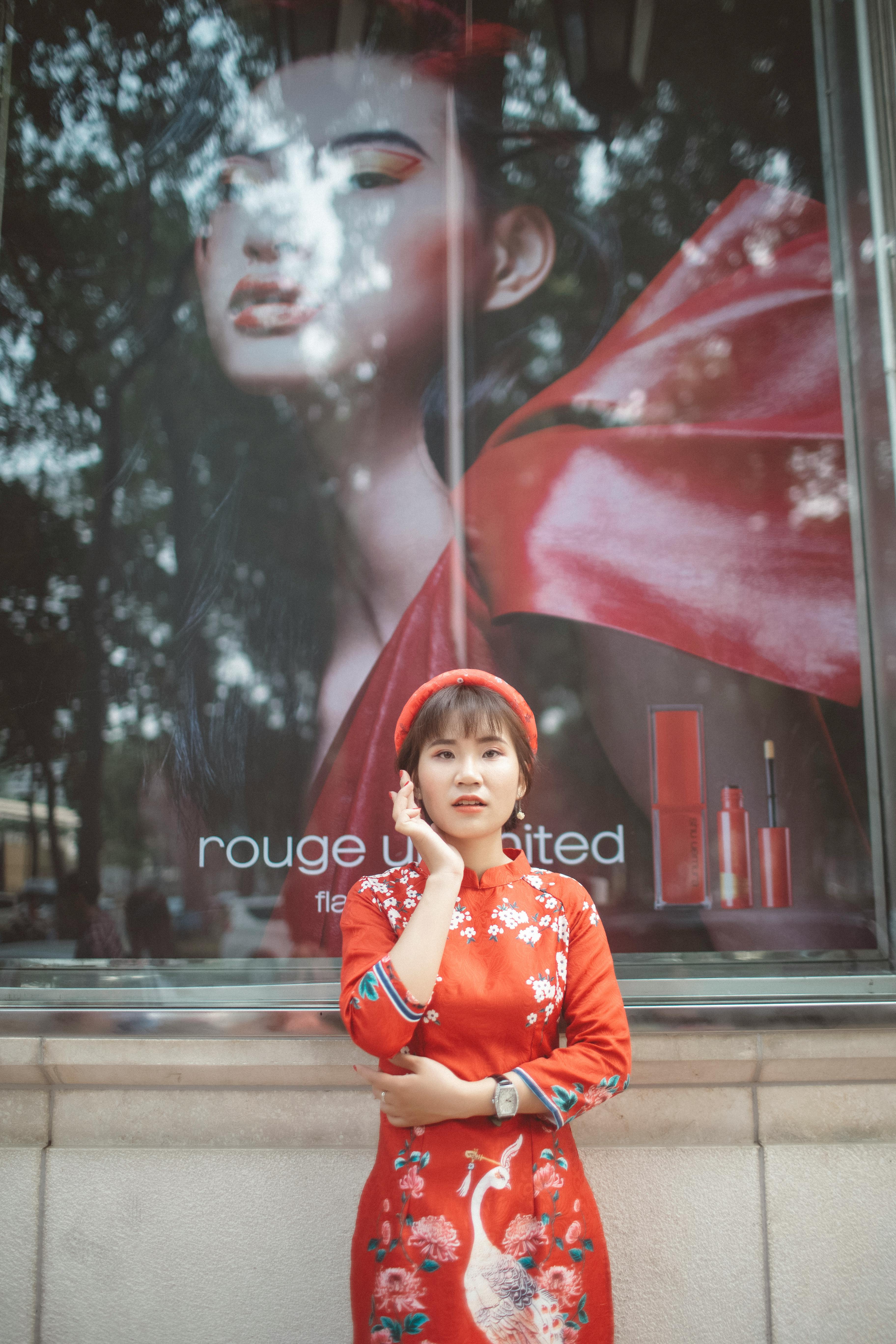 woman in red traditional dress standing in front of a glass window