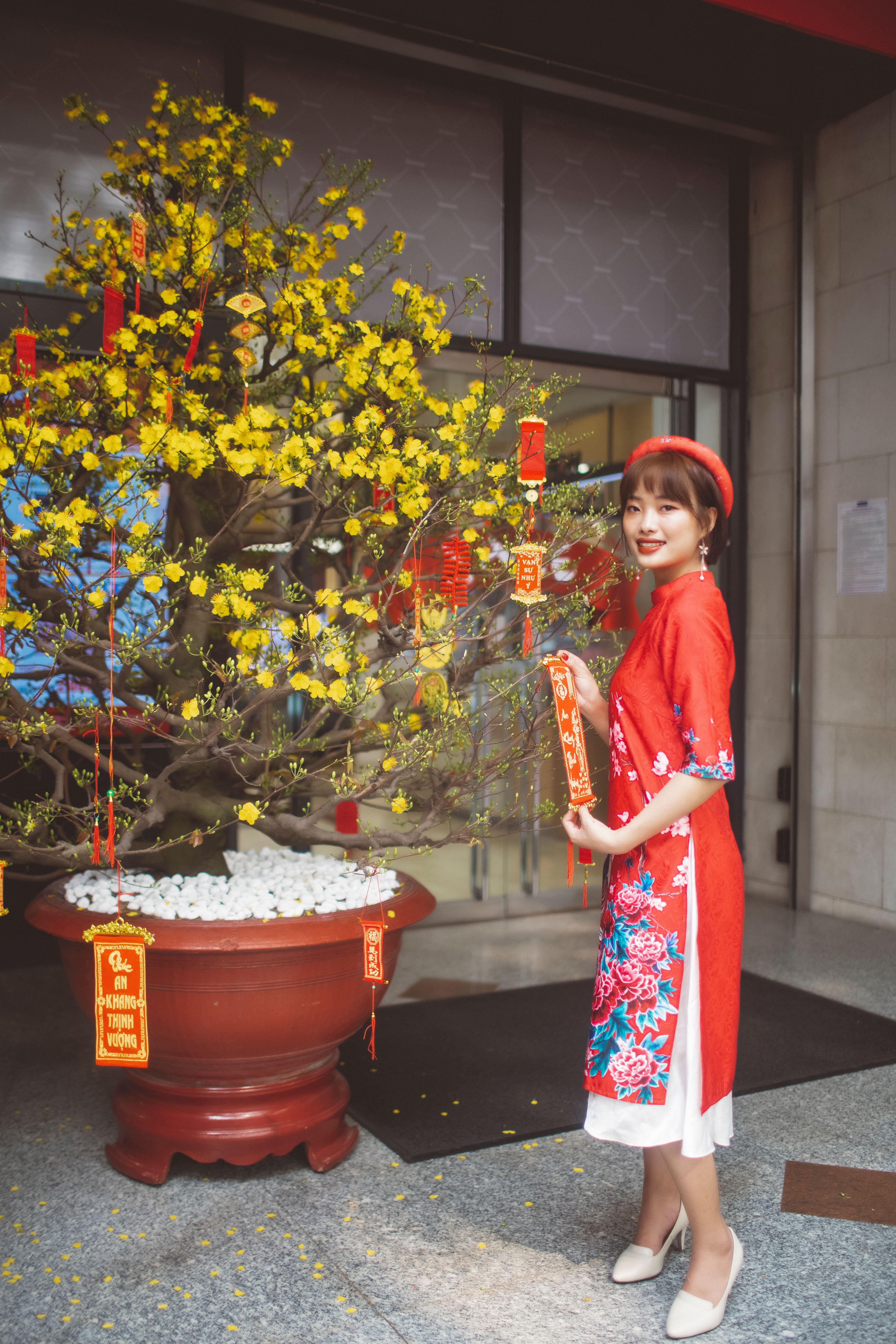 春节时，一位亚洲妇女在树旁微笑，庆祝农历新年