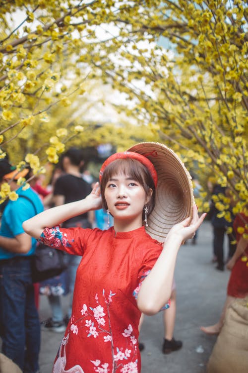 Girl in Red Traditional Dress Holding A Conical Hat and Posing