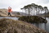 在苏格兰高地一处风景优美的湖边，一名男子快乐地跳跃，捕捉冒险与自然美景