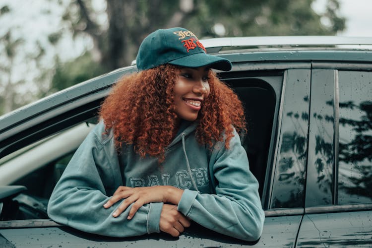 Happy Trendy Black Woman Looking Out Of Car Window