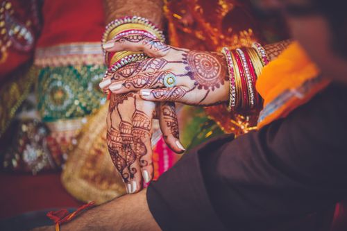 Free Detailed view of hands adorned with henna, colorful bangles, and traditional attire. Stock Photo