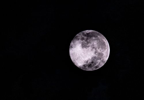 Free Crisp image of the full moon illuminating a dark starry night sky, capturing lunar details. Stock Photo