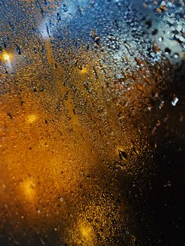 Raindrops on glass with vibrant lights create a moody ambiance. Captured in Shanghai.