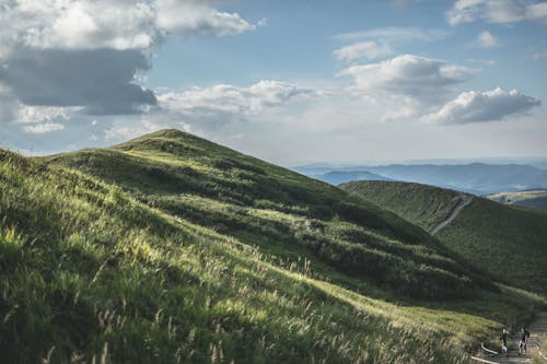 Mountains With Green Grass Under White Clouds