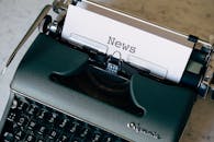 Green Typewriter With White Paper