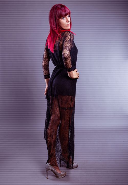 Free Fashion portrait of a woman posing in a black lace dress with vibrant pink hair. Stock Photo