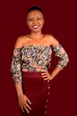 Cheerful black woman in trendy outfit in studio