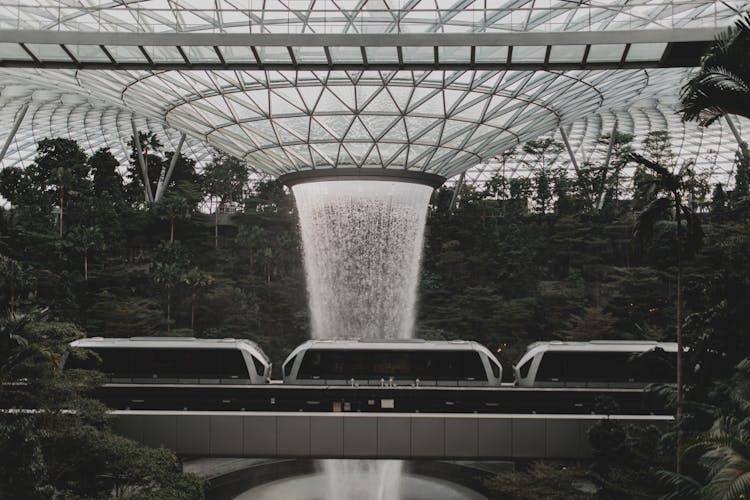 Futuristic Architecture With Indoors Waterfall And Rail Link Train