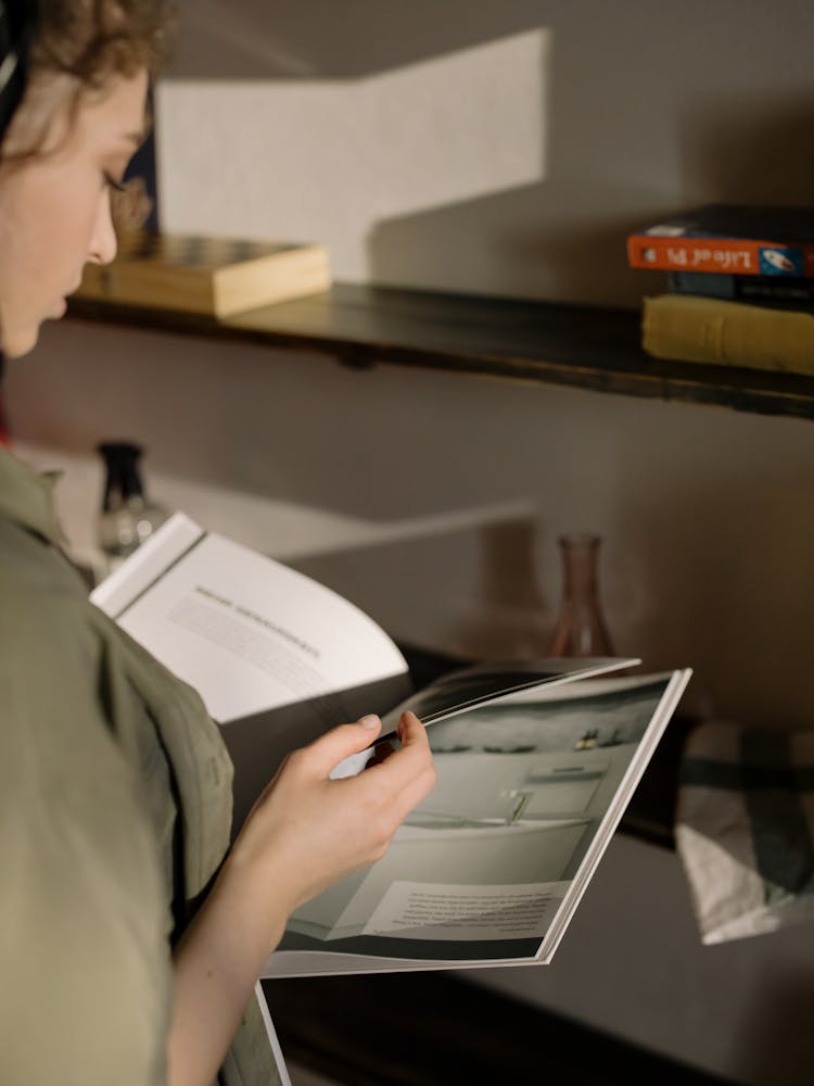 Person Turning Pages Of A Magazine 