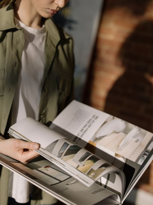 Free Close-up of a person browsing through a design magazine indoors. Stock Photo