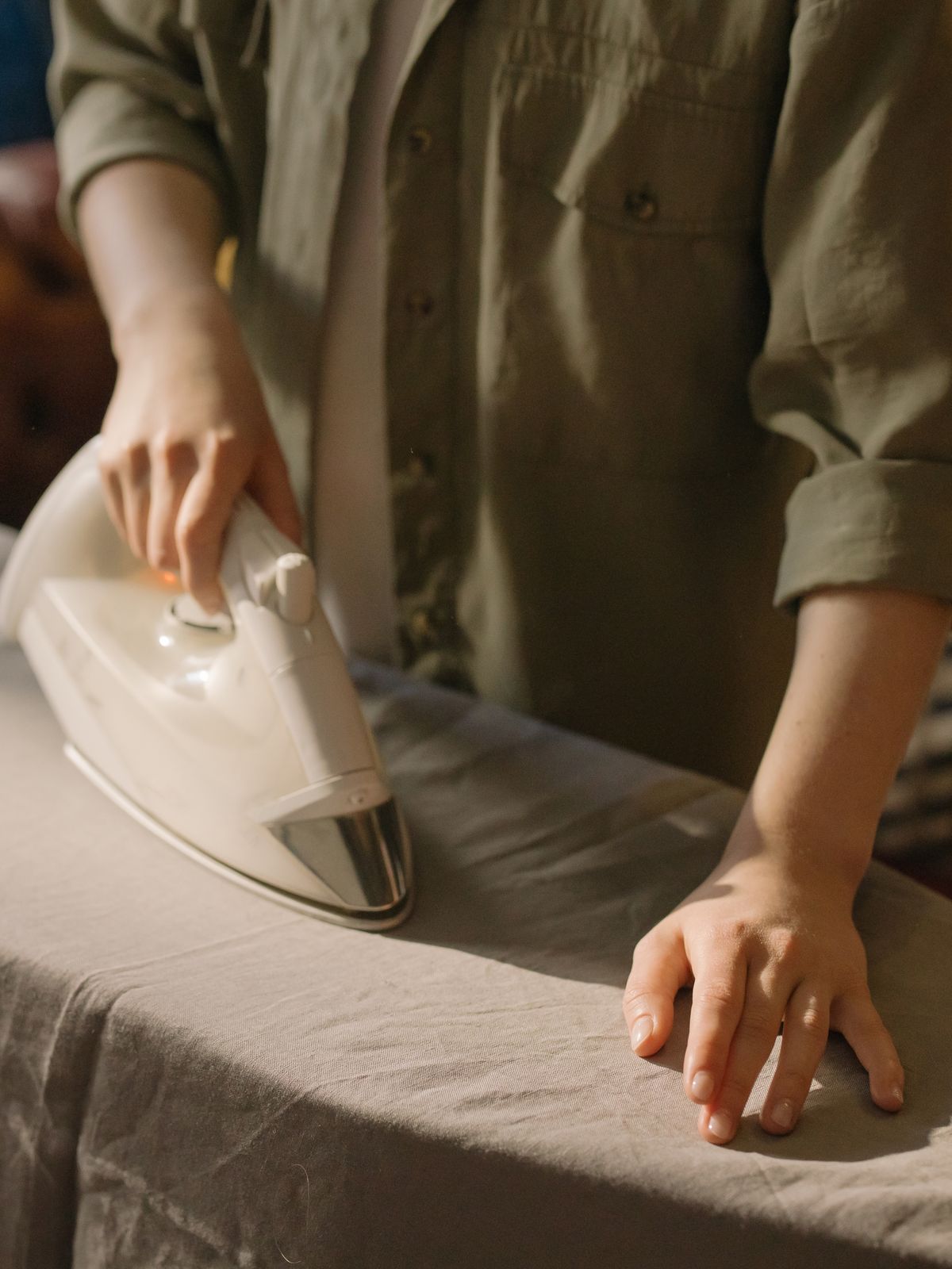 Person dusting a shelf with cloth and spray
