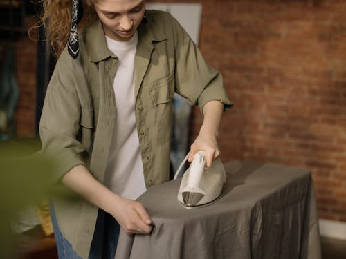 Woman in Brown Button Up Shirt Holding White Ceramic Mug