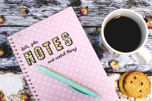 Pink Notebook Beside Cup of Coffee and Cookies
