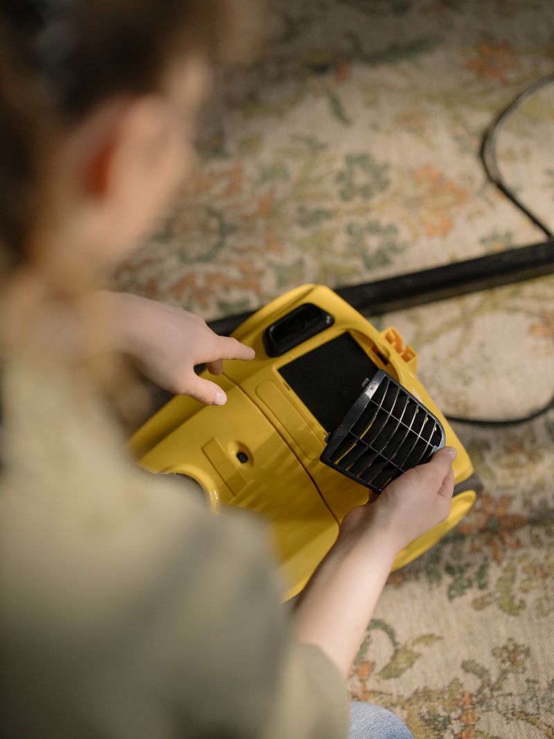 Person dusting a bookshelf carefully around items