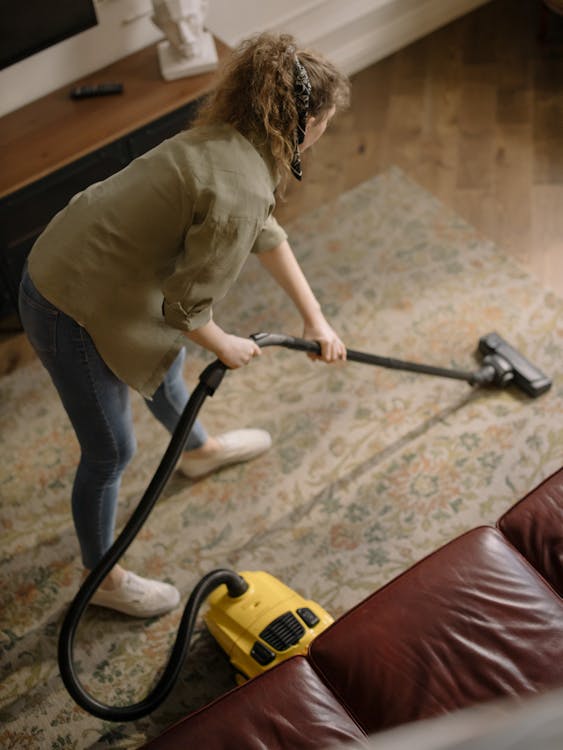 Free Woman in Long Sleeve Shirt Holding a Vacuum Cleaner Stock Photo