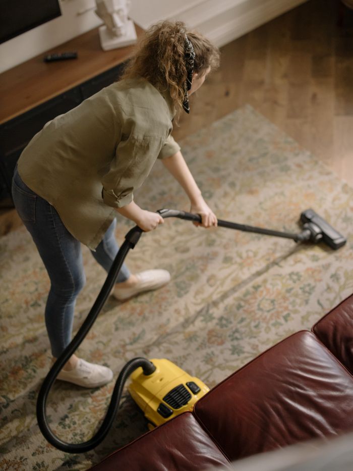 Woman vacuuming a patterned carpet in a stylish living room