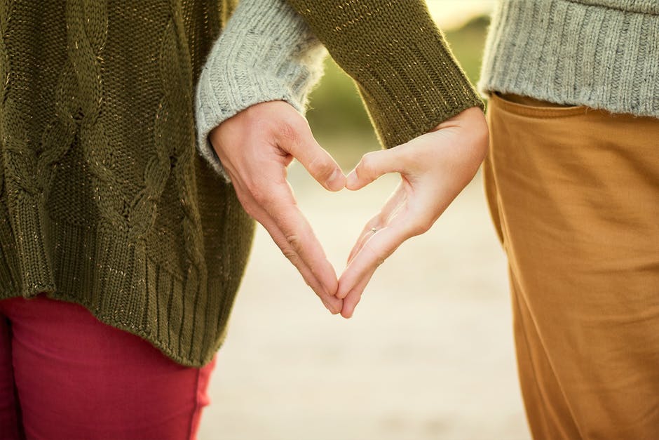 Selective Focus Photography Two Person Making Heart Hand Sign