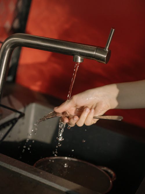 Free Person Holding Stainless Steel Faucet Stock Photo