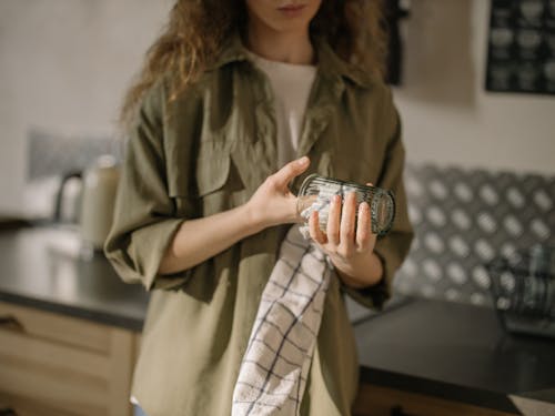 Free Woman in Brown Coat Holding Clear Glass Mug Stock Photo