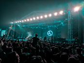 Back view crowd of anonymous people dancing and clapping during outdoor live rock festival at night
