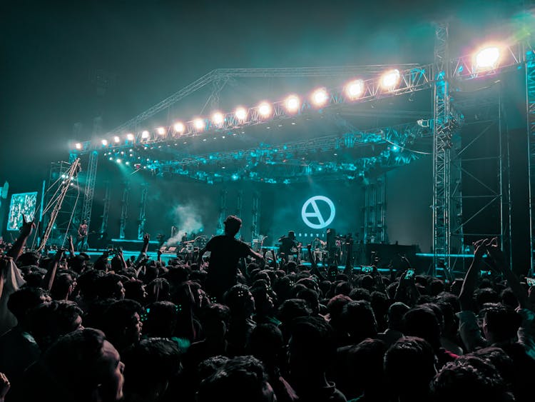 Group Of Unrecognizable Fans Cheering At Rock Concert