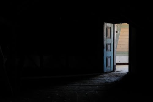 Free An Open Wooden Door in a Dark Room Stock Photo