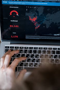 Person using laptop to view COVID-19 data map and statistics.