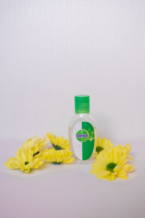 Free A bottle of disinfectant surrounded by yellow flowers, perfect for health and wellness themes. Stock Photo