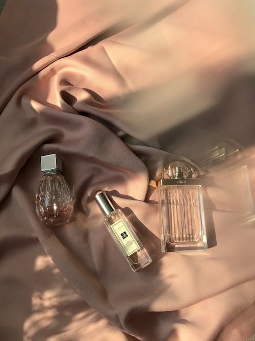 Clear Glass Bottles on Brown Textile