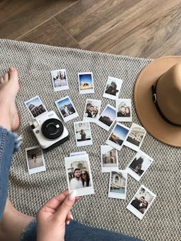 Flat lay of instant photos and a camera on a mat, capturing travel memories.