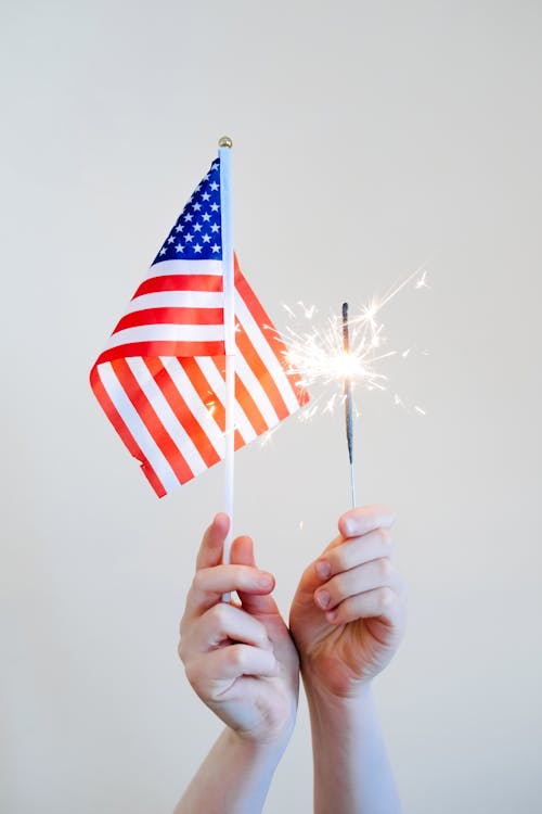 Hands Holding American Flag and Sparklers