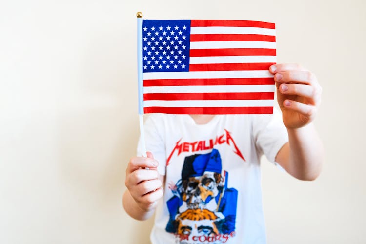 Man In Metallica Shirt Holding An American Flag Over His Face 