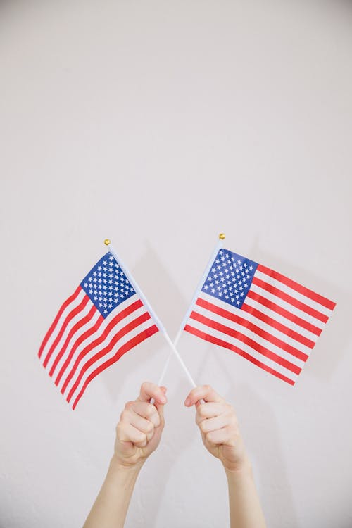 Gratis lagerfoto af Amerikansk flag, hænder, holder højt