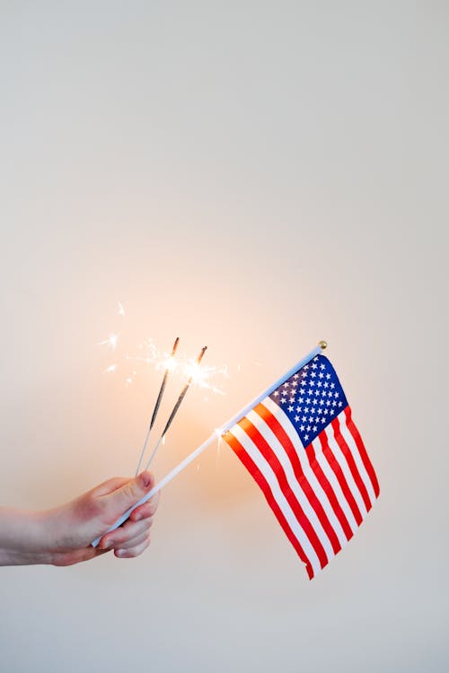 Hand Holding Sparklers and American Flag