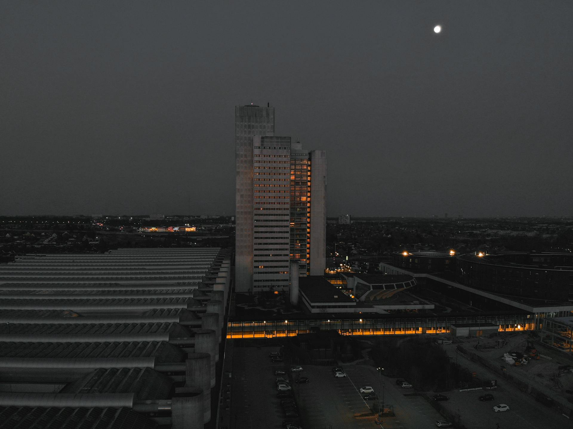 Stunning aerial night shot of Herlev Hospital in Denmark with illuminated windows and urban landscape.