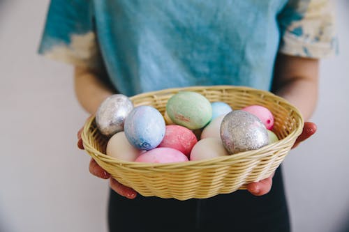 Person Holding a Woven Basket With Easter Eggs