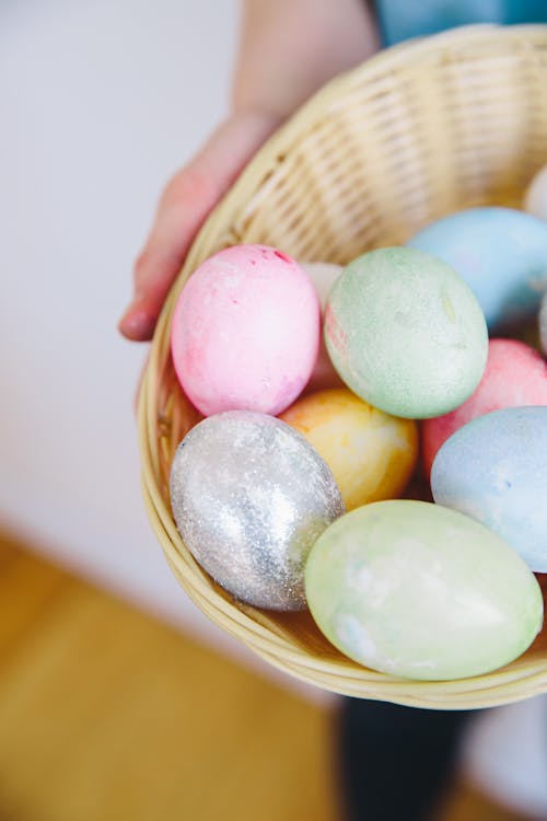 Person Holding a Woven Basket Full of Easter Eggs