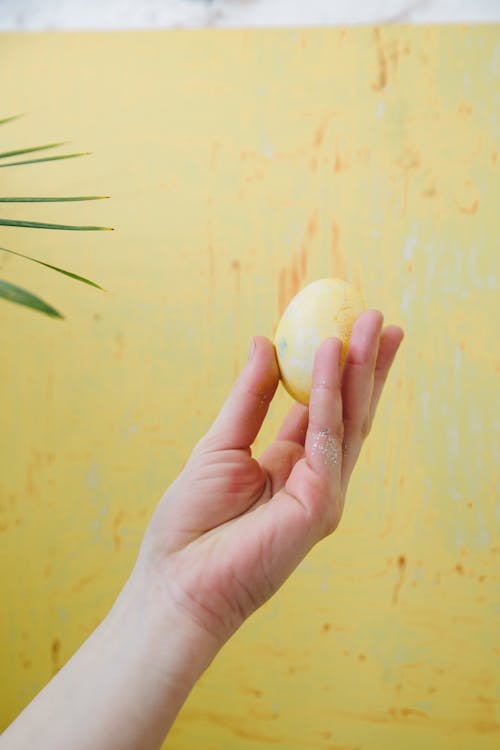 Person Holding a Yellow Easter Egg