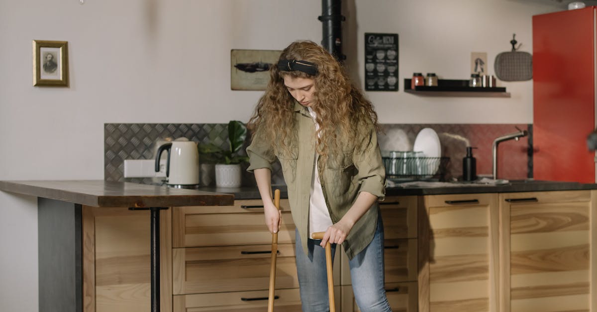 Woman in Gray Jacket Standing Beside Kitchen Counter
