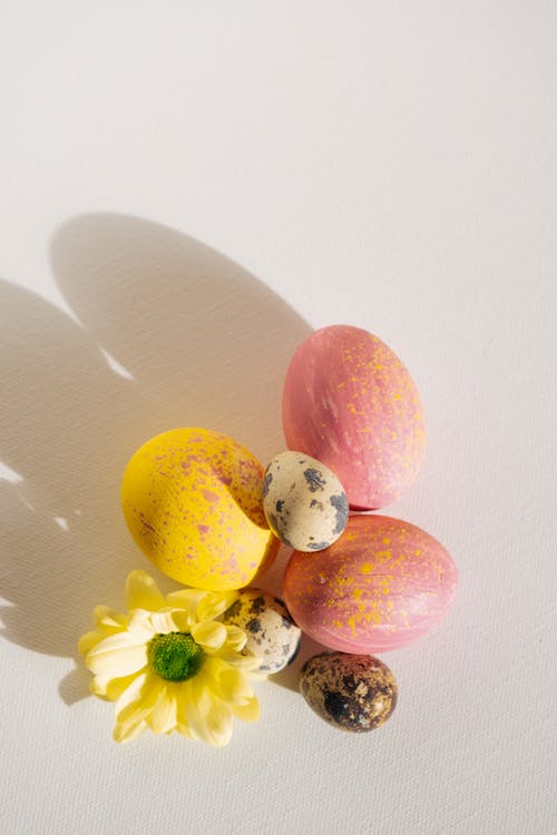 Pink and Yellow Easter Eggs With Quail Eggs and a Flower