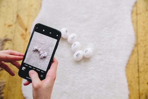 Person Taking a Photo Of Eggs With Letters