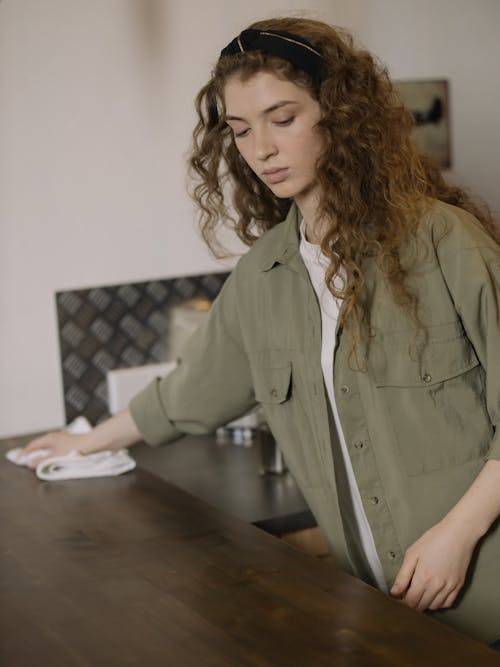 Free Woman in Gray Button Up Long Sleeve Shirt Sitting by the Table Stock Photo