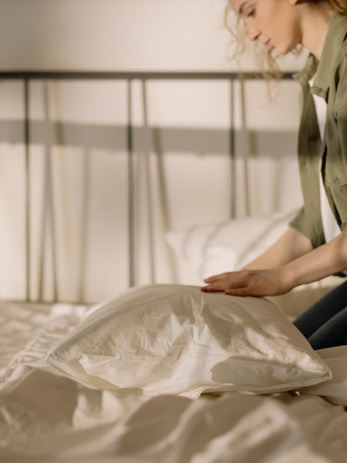 Woman in White Dress Shirt Sitting on Bed